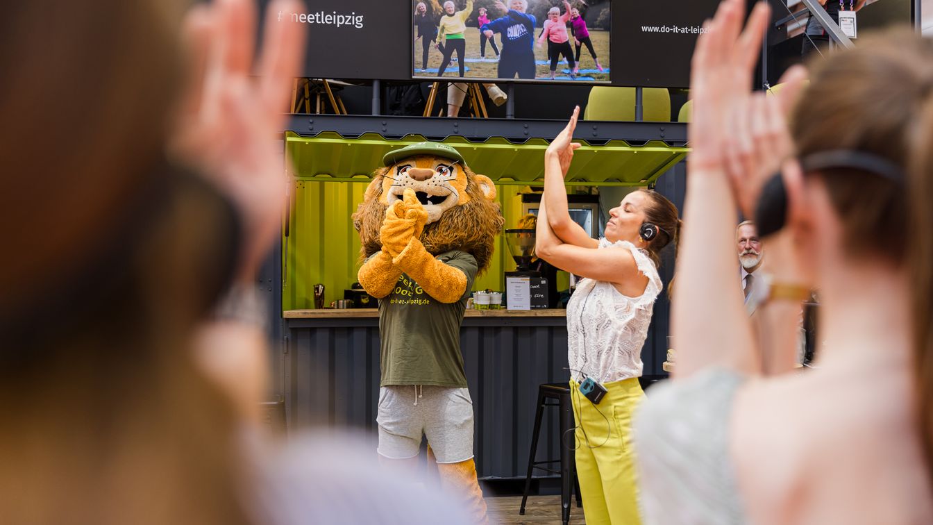 Tagung & Konferenz Leipzig Convention: Yoga mit Maskottchen Tammi am Leipzig-Stand auf der IMEX Frankfurt 2024 